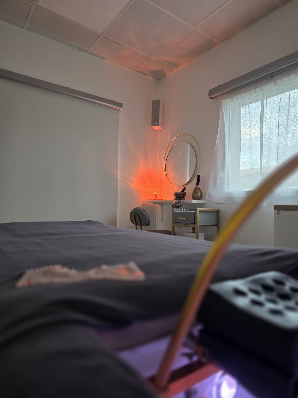 Cabine de soin à l’ambiance chaleureuse, lampe de sel et miroir rond