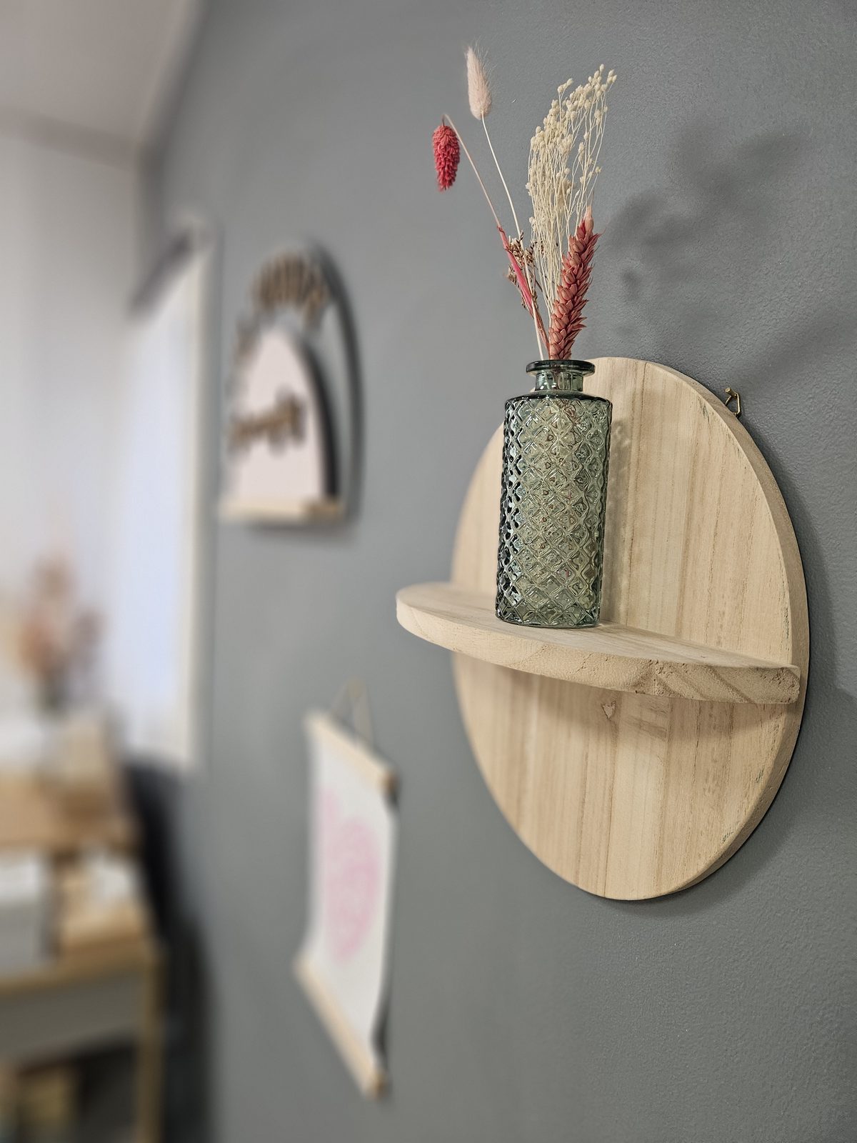 Étagère en bois et fleurs séchées sur un mur gris anthracite